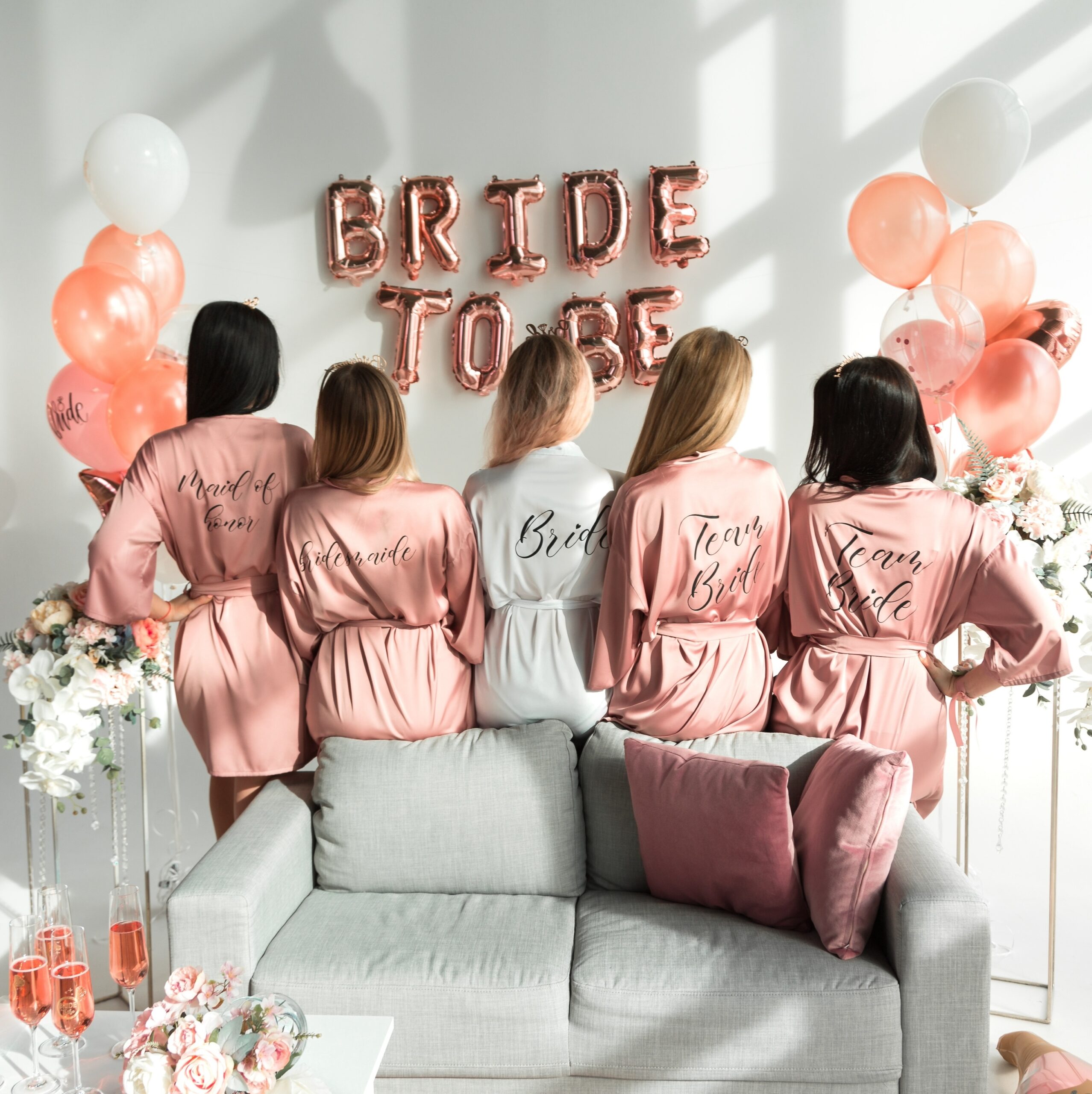 Bride with girlfriends in silk robes at a bachelorette party.